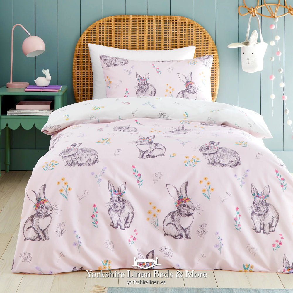 Pink reversible kids duvet cover set with white bunny rabbit tails design, shown in a styled bedroom - Yorkshire Linen Mijas Costa.
